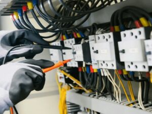 Electrician testing electrical panel with multimeter